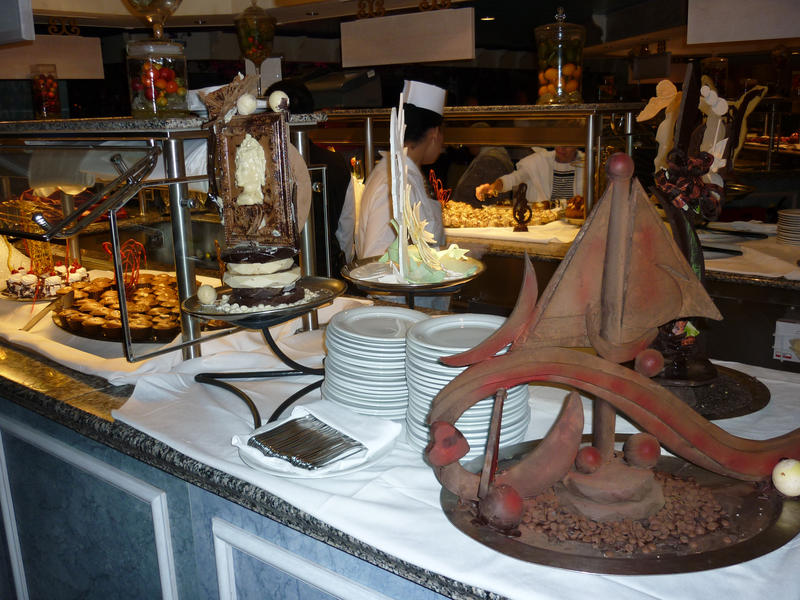 Food buffet table with nautical themed decoration and an assortment of food dishes and serving plates