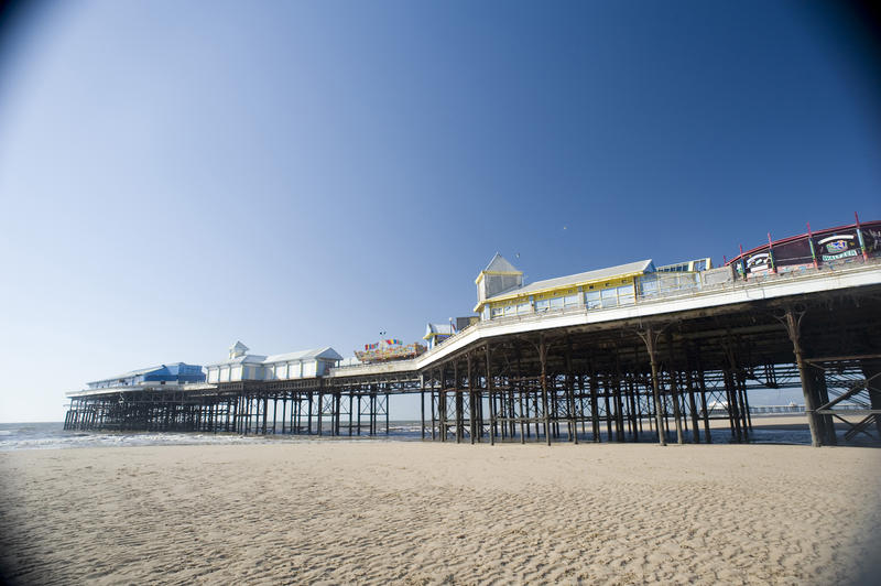 Blackpool central pier looking across the sandy beach at low tide, low angle view on a sunny day