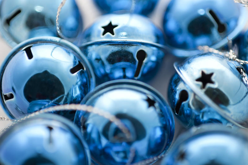Closeup Christmas festive background of shiny blue jingle bells ornaments