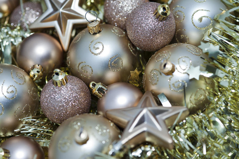 Seasonal background of a selection of different gold Christmas decorations, stars and tinsel