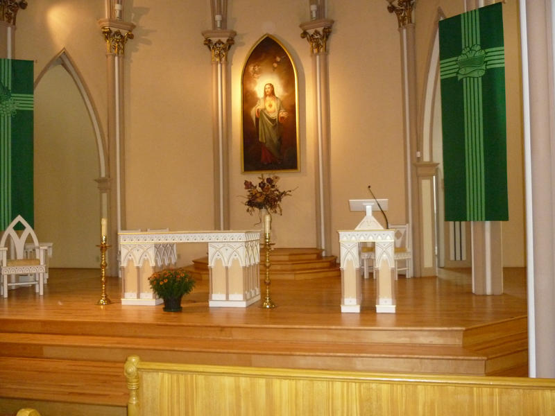 Altar at St Georges Church with beautiful flowers, wooden pews and a painting of Christ