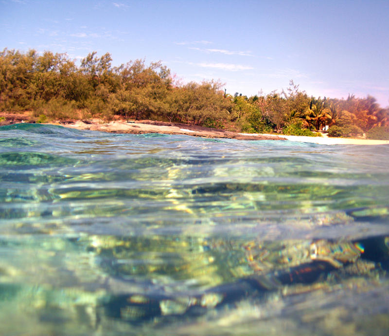 Sparkling clear ocean water ebbing and flowing off the beaches of a tropical island