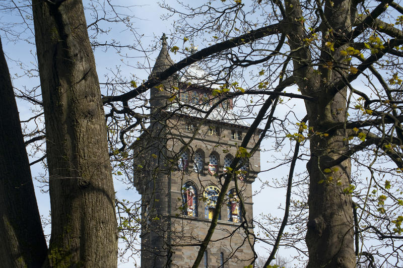 View through bare tree branches of the historic Clock Tower on Cardiff Castle, Newport, Wales