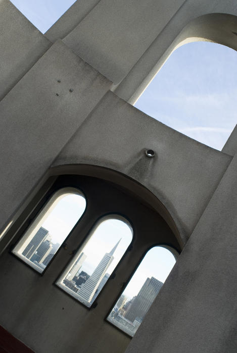 distinctive buildings of downtown san francisco as seen through the windows at the top of the coit tower