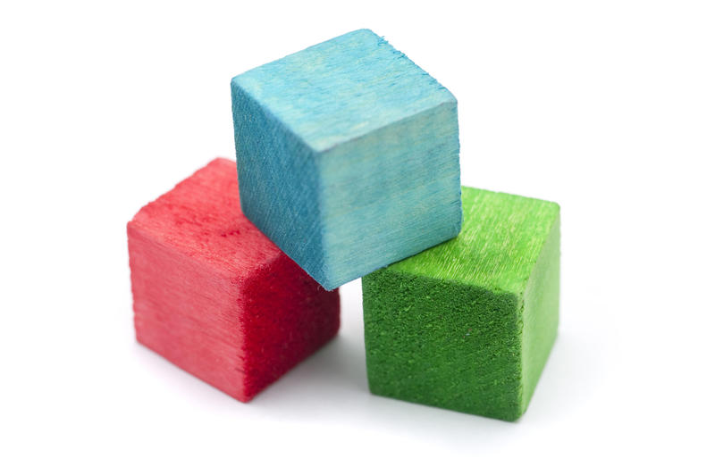 Three colourful wooden building blocks for teaching young children coordination and for use as an educational tool