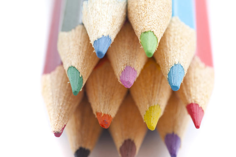 Artistic background of the colourful palette of pencil crayons with a close up view of the sharpened points facing the camera