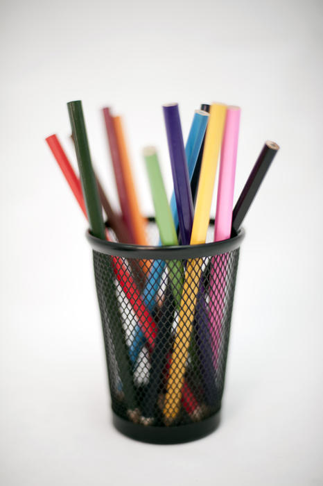 Coloured pencil crayons in a container for use in sketching, drawing and colouring in