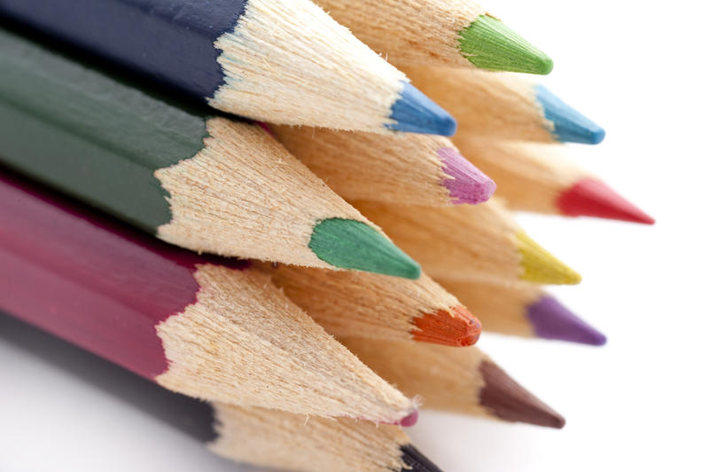 Closeup of the tips of a selection of colouring pencils over white background
