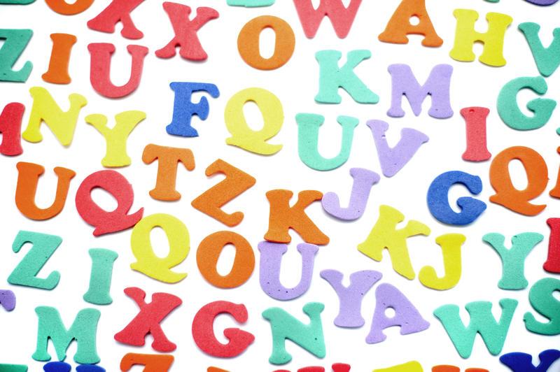 Random colourful consonants and vowels scattered on a white surface for use in teaching preschool children their alphabet