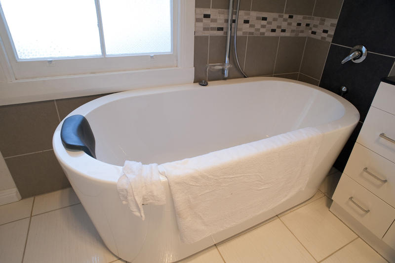 Modern freestanding bathtub in a contemproary bathroom interior with a towel hanging out to dry
