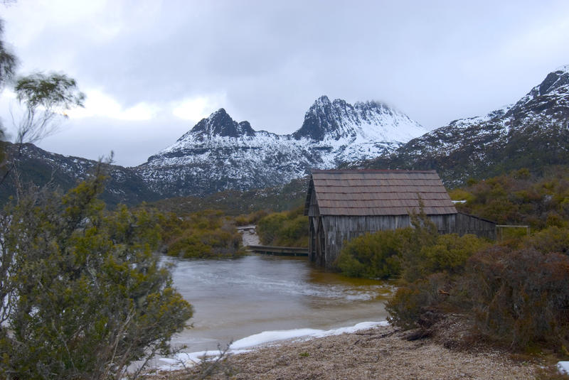 old wooden boatshed on dove lake, cradle mountain in the background, tasmania