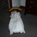 6755   Antique doll lying in a crib