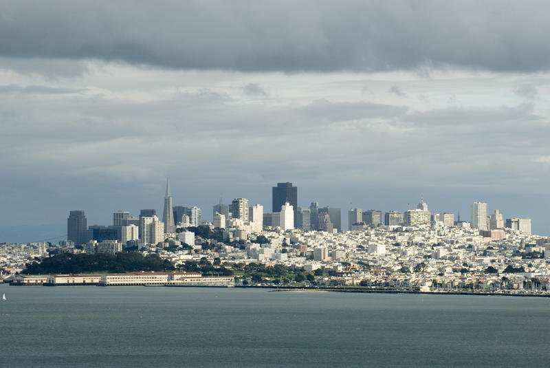 san francisco downtown as viewed from the golden gate under a cloudy sky