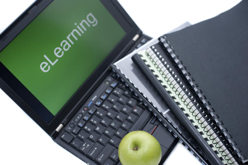 Paper notebooks and electronic notebook with green apple