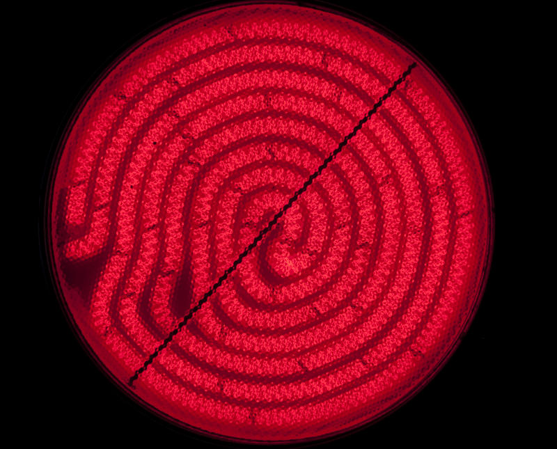 bright red glowing heating element of an electric cooker hotplate