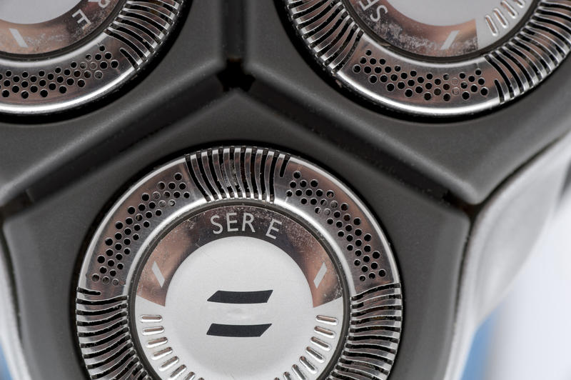 Closeup of one of the three circular stainless steel blades of an electric shaver for trimming facial hair
