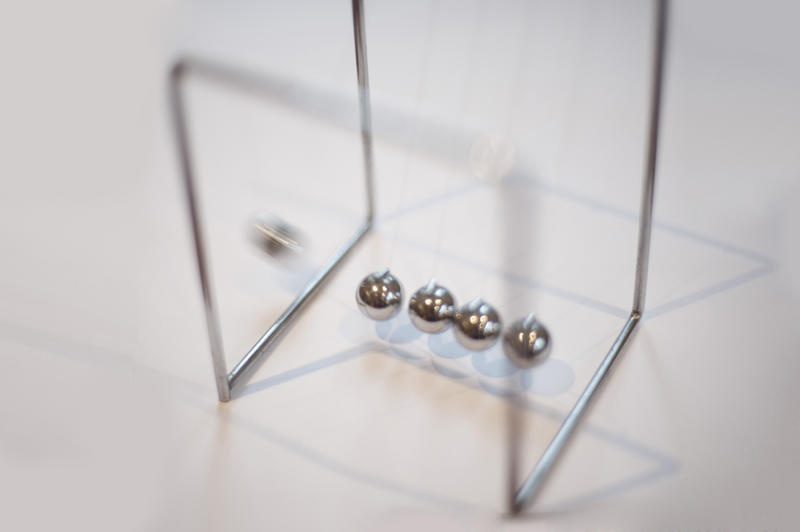 Executive stress toy or Newton's cradle with suspended metal balls allowing the transfer of motion from one end to the other