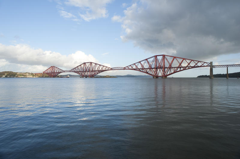 wide angled view of the firth of forth on a calm day with the famous forth rail bridge crossing the waters