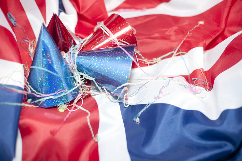 a party background featuring a uk flag, red and blue party hats with streamers