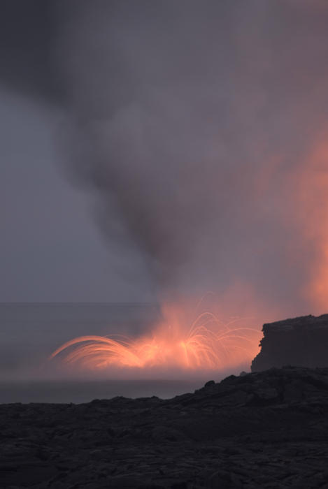 amazing view of lava entering the ocean and spewing clouds of steam, near Kalapana, Hawaiis Big Island