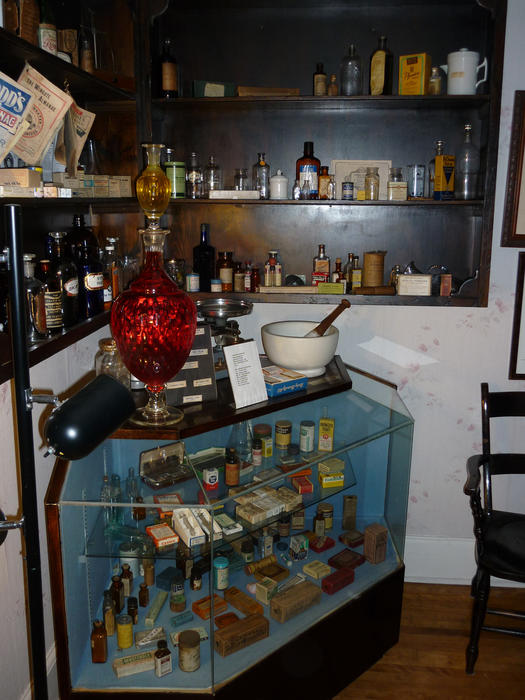 Interior of a historic store with an old glass counter, paraffin lighting, pestle and mortar and stock dating back to the 19th century