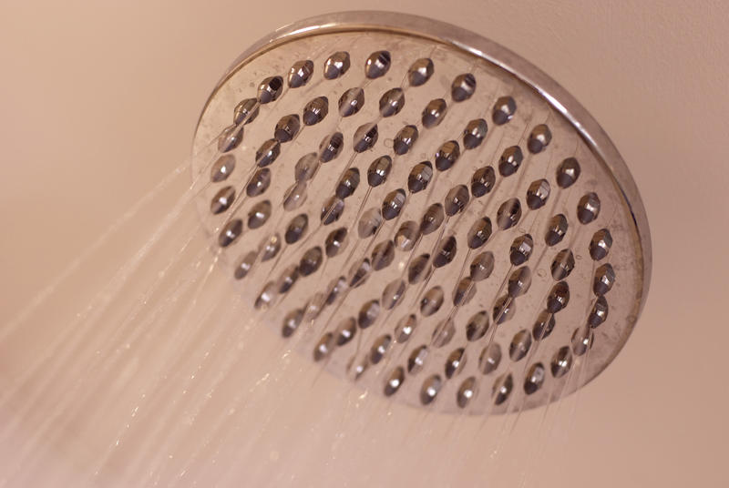 a large metal shower head with hot running water
