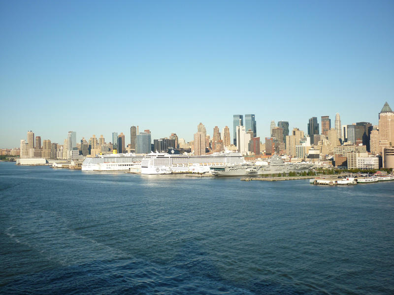 View from the Hudson River of passenger cruise ships and shipping moored at the wharfs against the skyscrapers and cityscape of Manhattan, New York