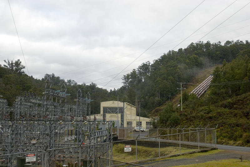 exterior of a hyrdro electric power station, substation switching gear and and feed water supply pipes can all be seen