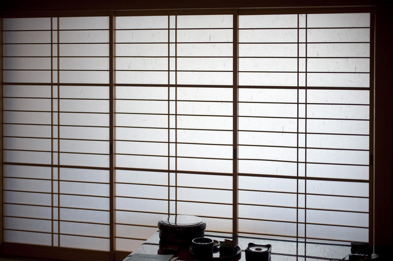 traditional japanese interior, paper screen and tea set silhouetted on a table