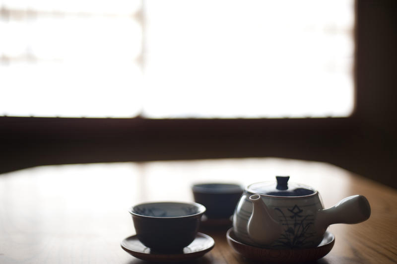 background image with two japanese tea cups, saucers and a tea pot