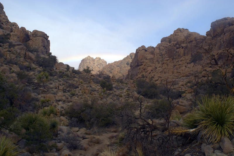 a rainbow over a rocky desert canyon, joshua tree national park, california