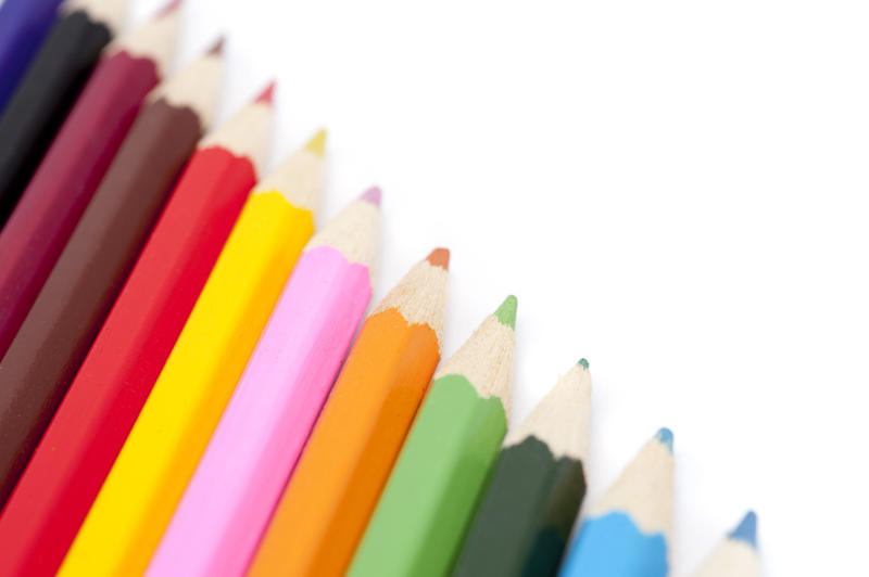 Sharpened wooden coloured pencils in a diagonal line in the colours of the spectrum for teaching art and drawing to children