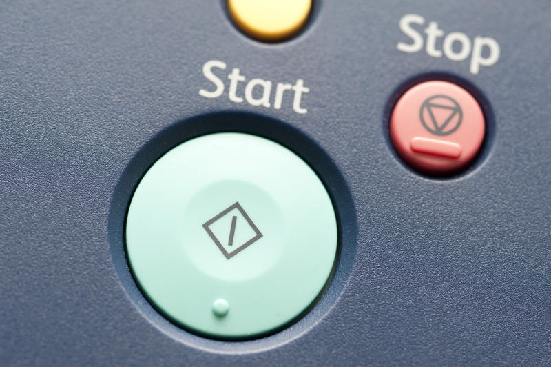 Green start and red stop buttons on laser printer