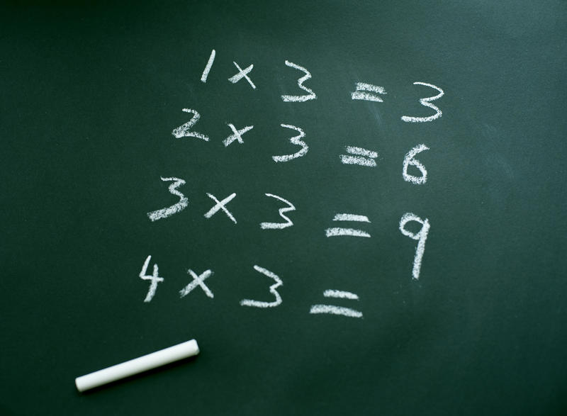 learning the three times table on a blackboard with chalk