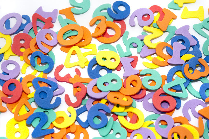 A colourful educational background with scattered numerals on a white surface, conceptual of learning numbers