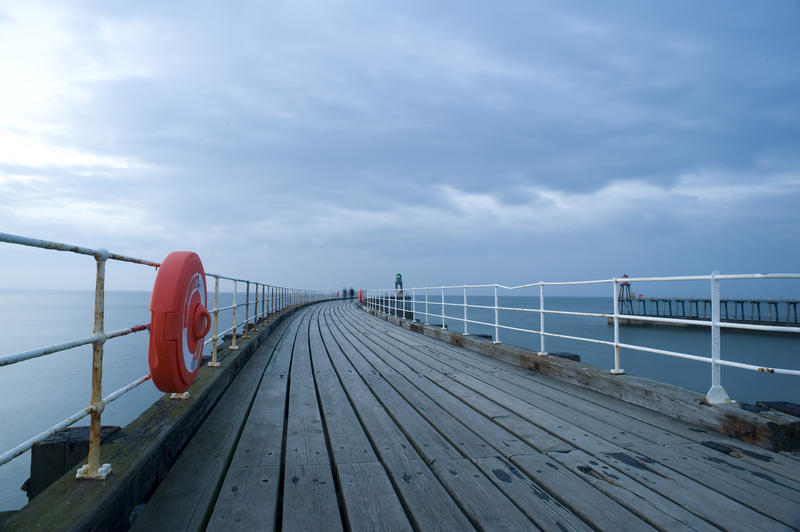 a bright red safety equipment case with a life ring on the side of a jetty