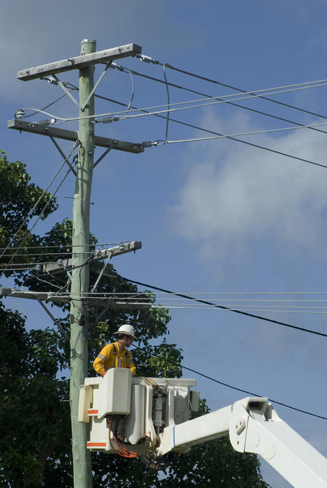 a linesman in a lift hoist working on the electrical network