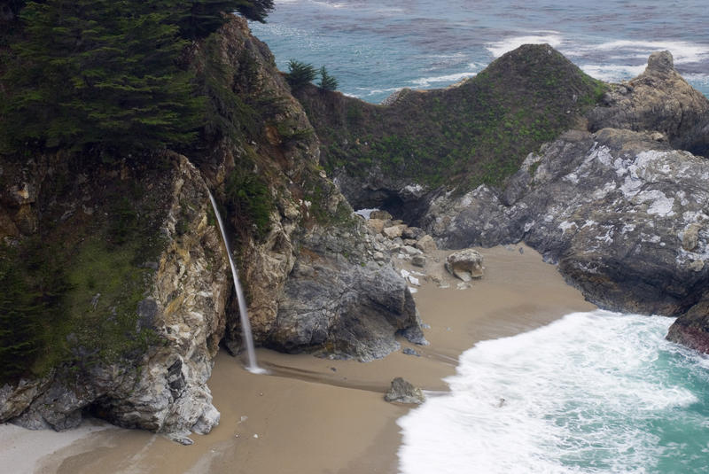 waves breaking on the beach at mcway cove with the famous cliffside waterfall near by, california
