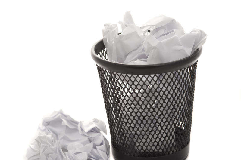 Mini wastepaper basket full to overflowing with crumpled white paper