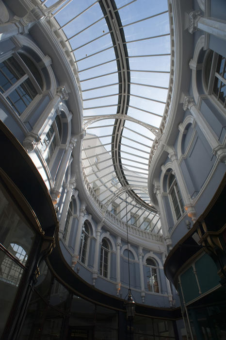 Curving glass roof and arched Venetian windows of the Morgan Arcade, a restored Victorian shopping arcade in Cardiff, Wales