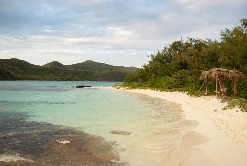 View along the deserted golden sand of a gently curving bay fringed with tropical vegetation on Naviti Island, Fiji