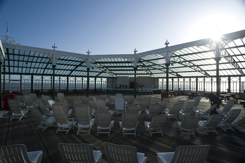 Sun loungers and seating on the decking of the Blackpool North Pier for relaxing and enjoying the blue sky and sunshine