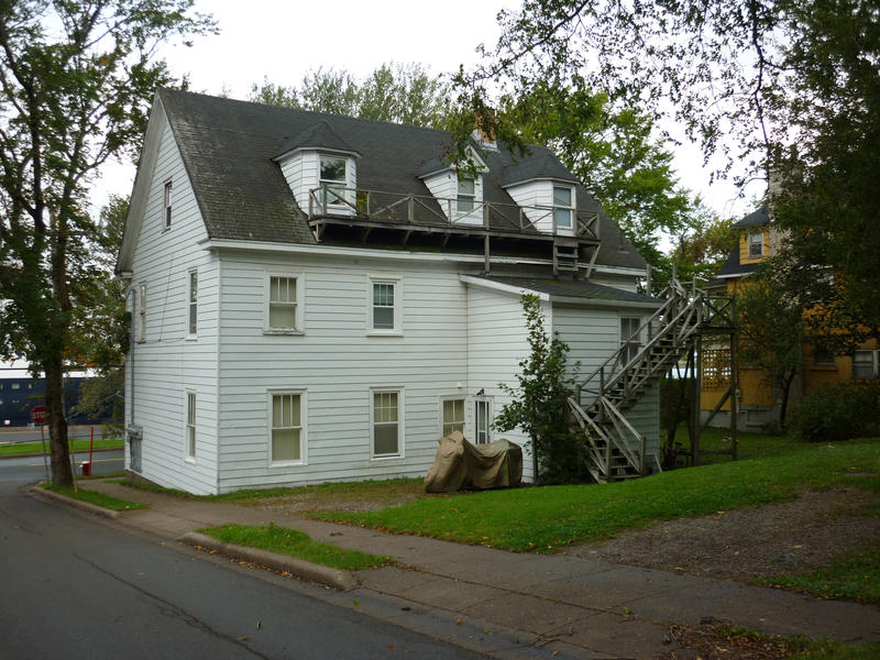 Old traditional wooden white painted house with dormer windows in Sydney, Nova Scotia
