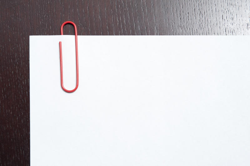Paperclip on a blank white document with a wooden textured border on two sides