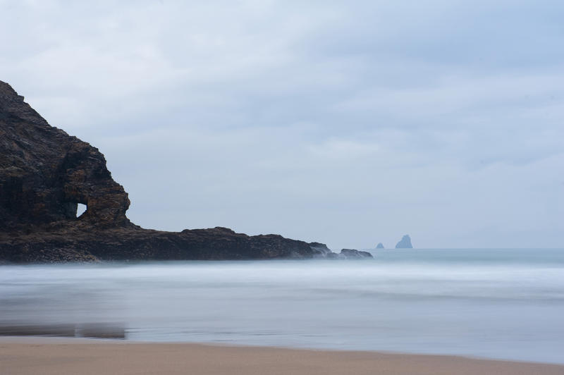 Coastline at Perran Beach, Perranporth, Cornwall with a calm sea on a misty overcast day