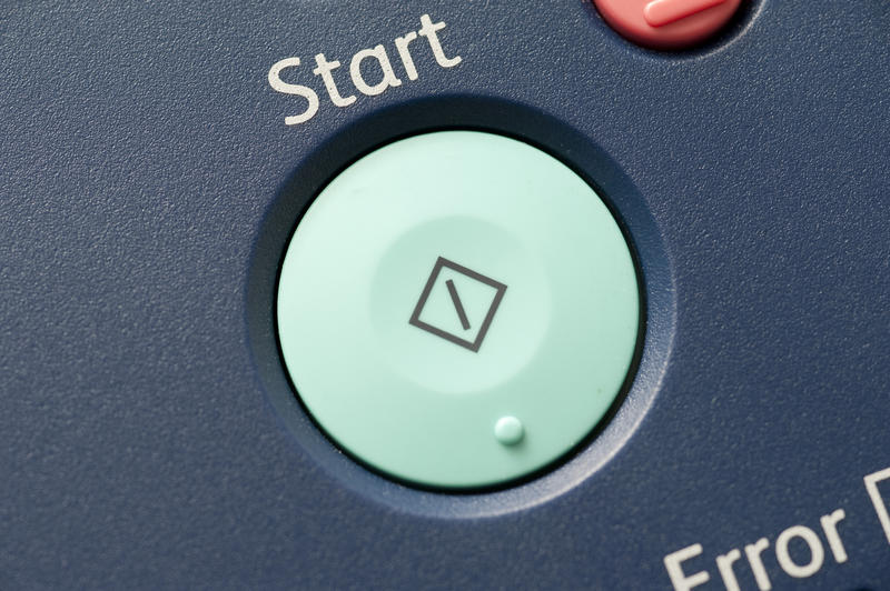 Large green Start button on electronic equipment with the text word Start above