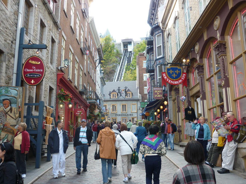 Quebec street scene below the funicular with crowds of tourists walking up the road between old historical buildings
