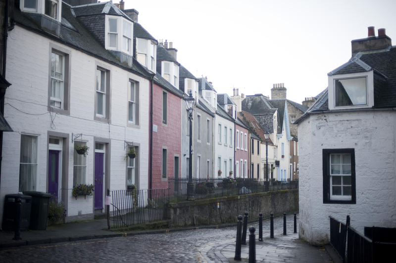 Cobbled street in Queensferry, Scotland lined with terraced houses on a grey day