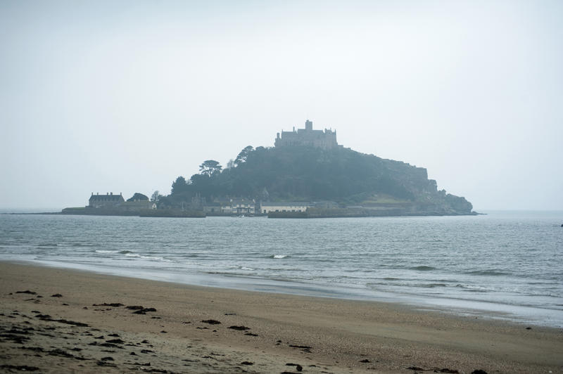 Looking across from an empty Cornish beach to St Michaels Mount, on a hazy day