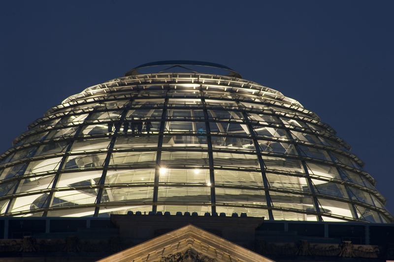 The illuminated glass dome of the Reichstag parliamentary building, Berlin, at night which allows a 360 degree view of the city